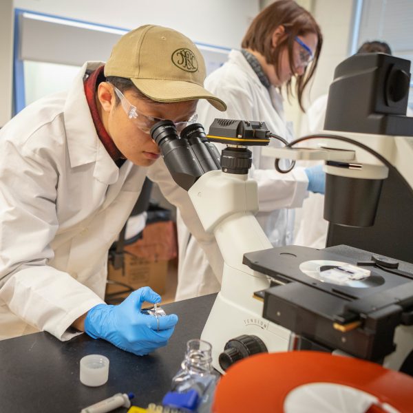 student with microscope